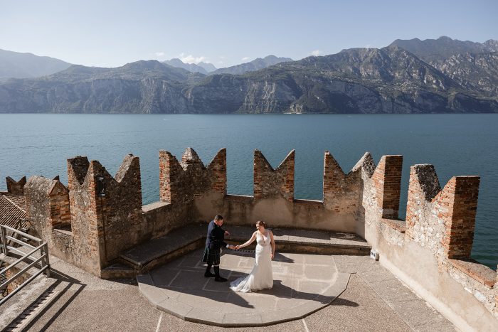 lake garda traditional wedding photography. Bride and groom during their wedding ceremony at Castello di Malcesine overlooking Lake Garda, Italy