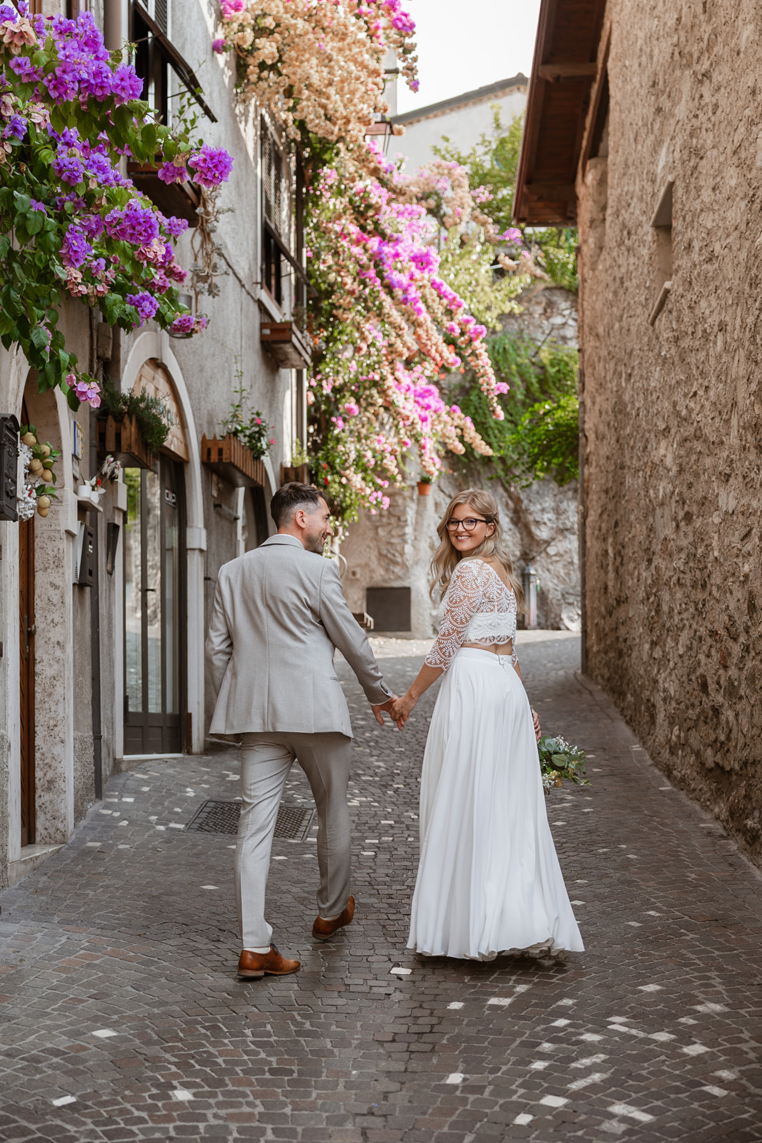 Fotografo matrimonio Limone sul Garda – sposi nei vicoli stretti del borgo con bouganville centro storico