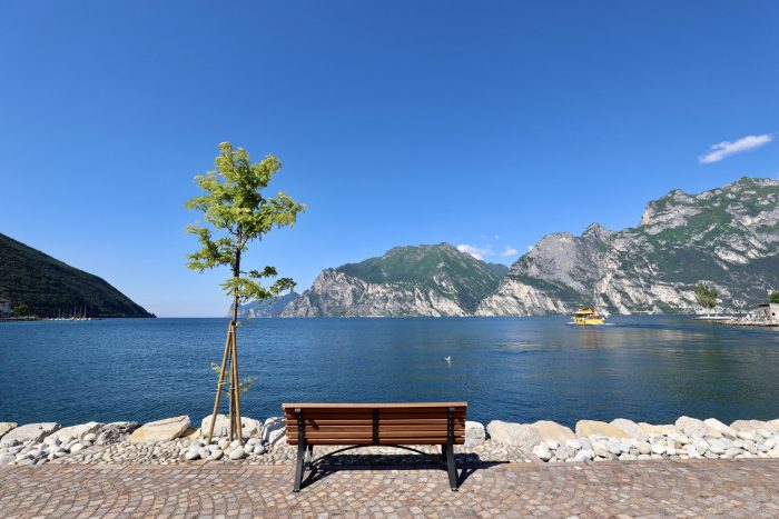 Panoramic view of Lake Garda wedding venues in Torbole sul Garda with mountains and lakefront promenade, a beautiful location for a destination wedding in Italy