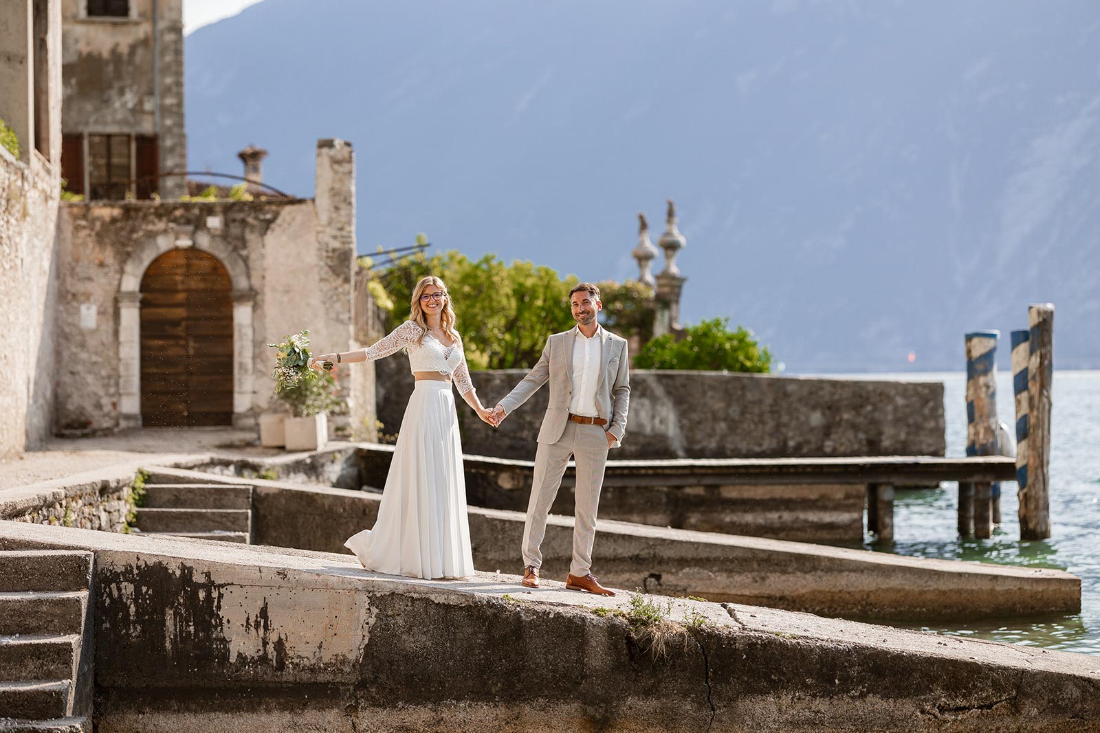 Bride and groom standing by Lake Garda in Limone sul Garda during their wedding day