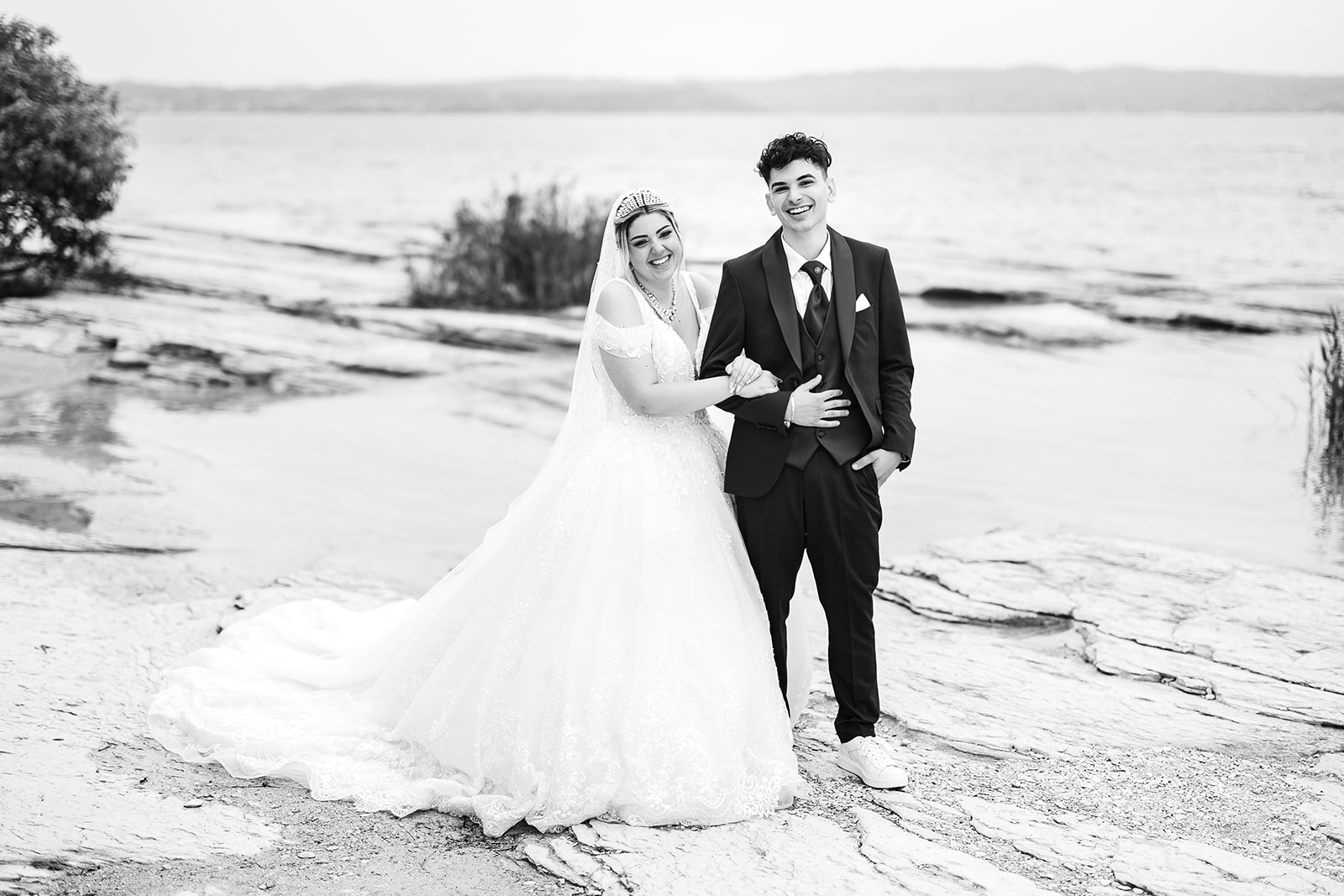 Sposi sorridenti e spontanei a Jamaica Beach a Sirmione durante un matrimonio sul Lago di Garda