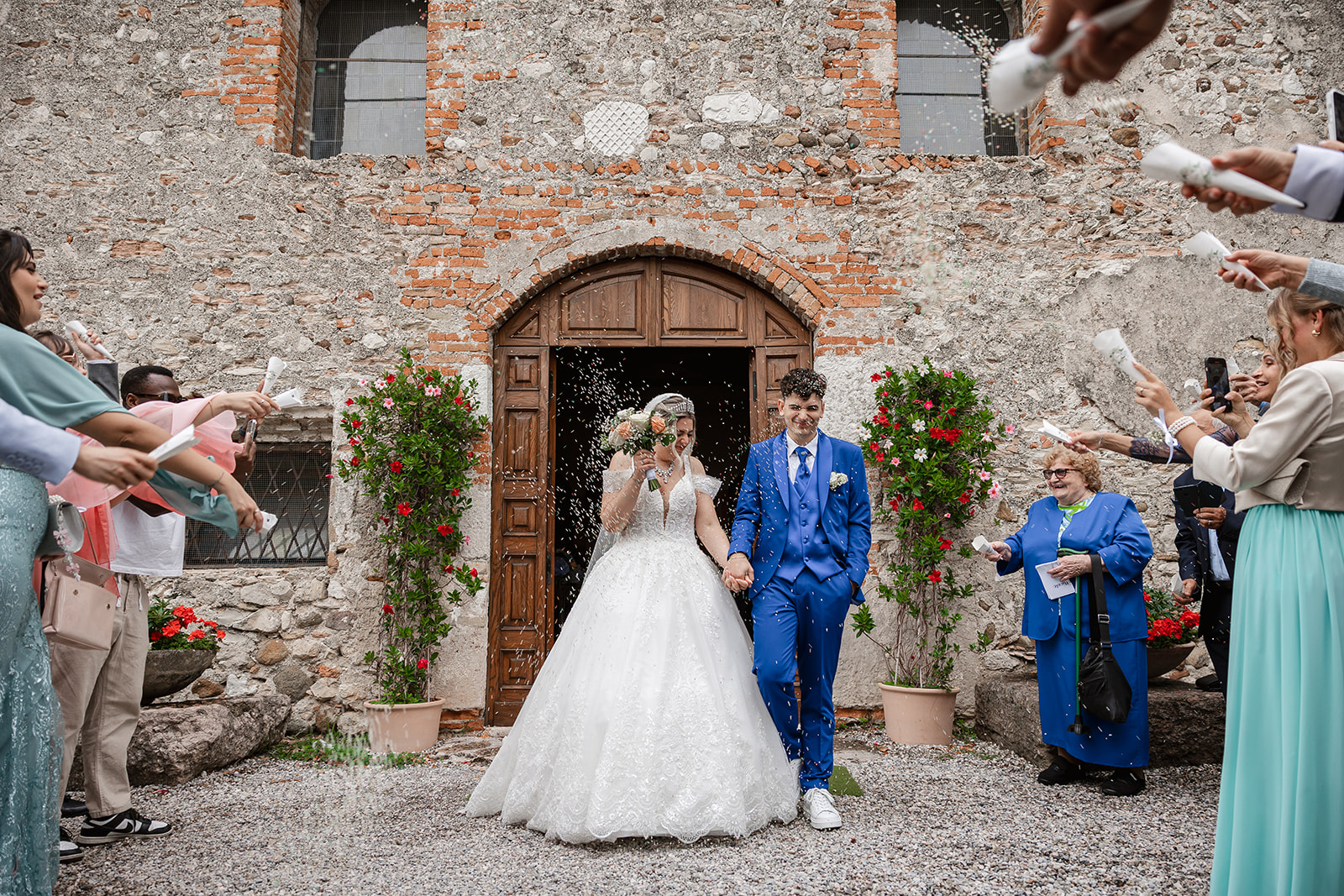 Bride and groom walking out of San Pietro in Mavino Church in Sirmione after their wedding ceremony. Sirmione wedding photographer