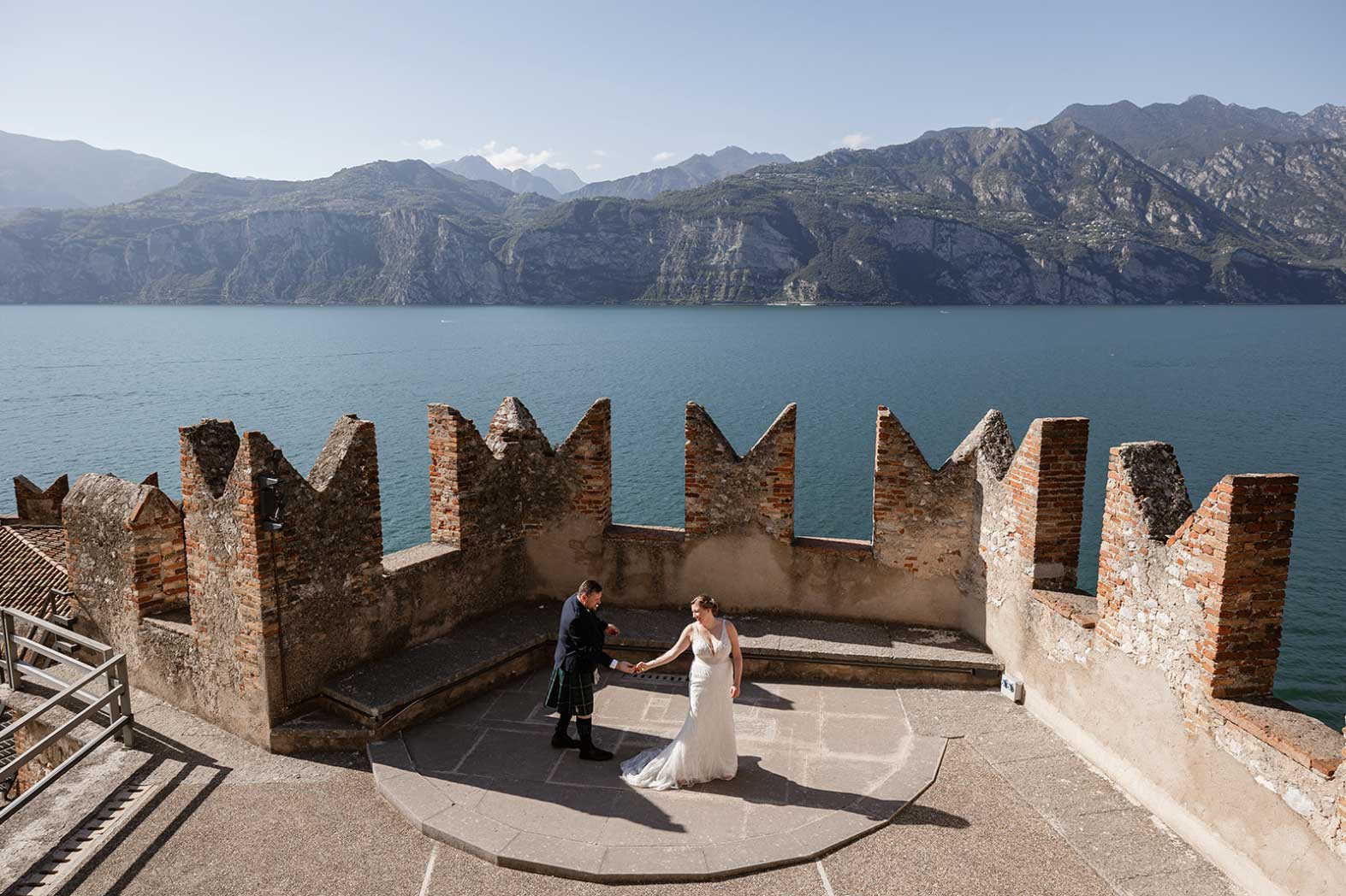 lake garda traditional wedding photography. Bride and groom during their wedding ceremony at Castello di Malcesine overlooking Lake Garda, Italy