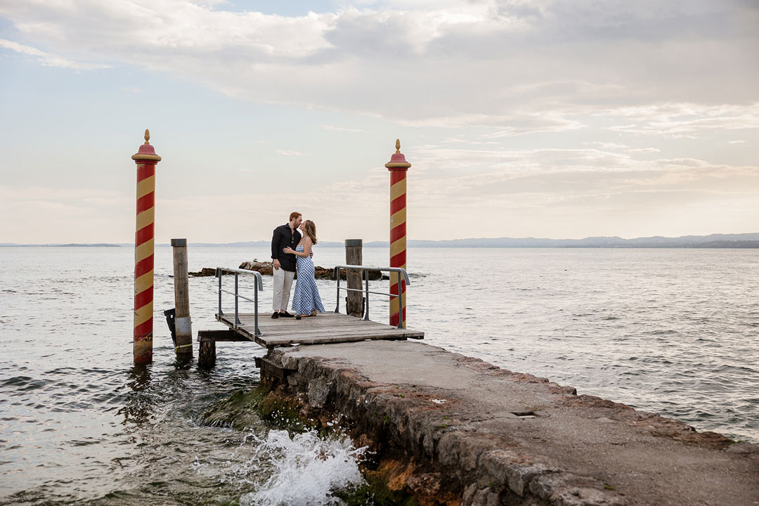 Couple kissing on a lakeside pier at Punta San Vigilio, Lake Garda
