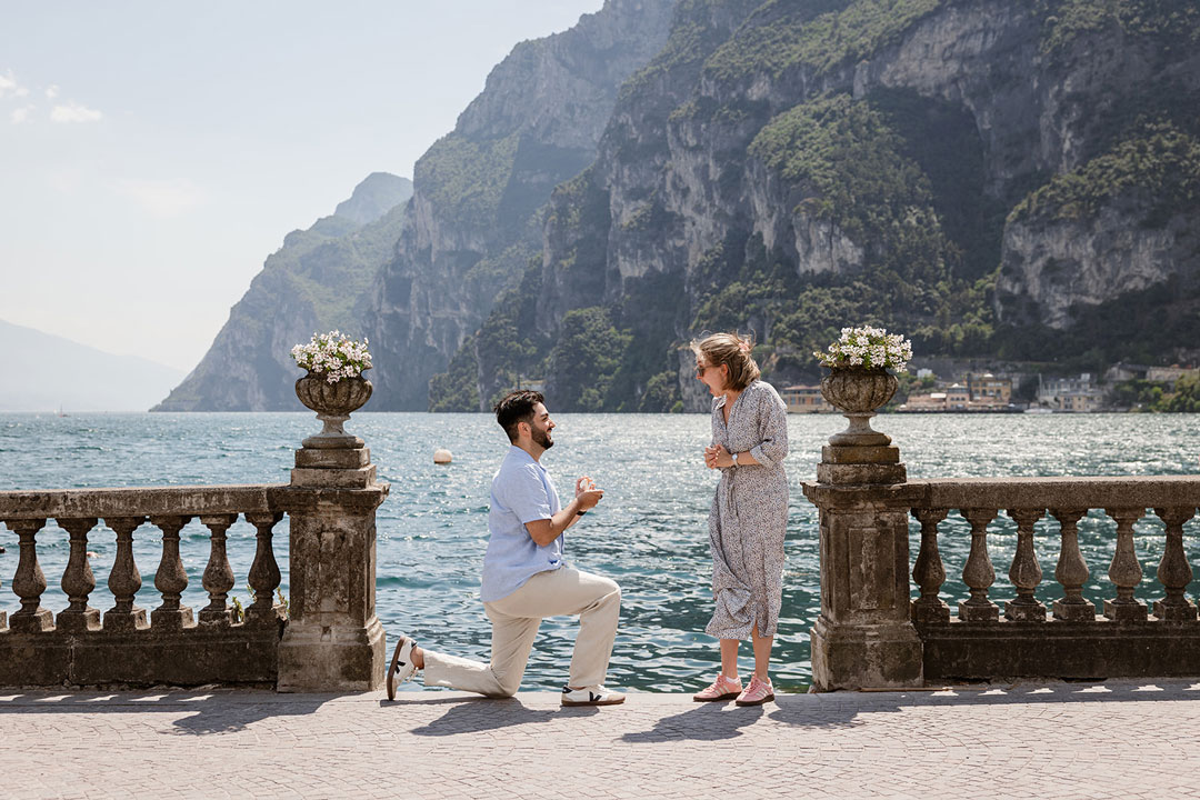 Man proposing to his partner by the lake in Riva del Garda